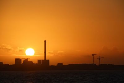 Silhouette of factory at sunset