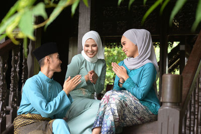 Smiling people talking while sitting outdoors