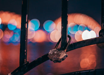 Close-up of illuminated metal against sky at night