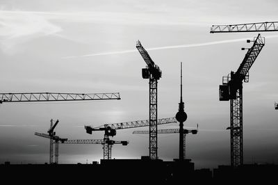 Low angle view of cranes against sky