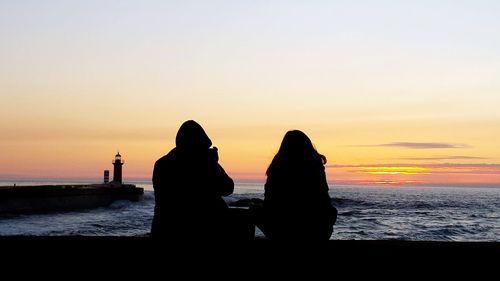 Silhouette people at beach during sunset