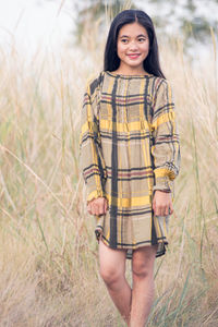 Portrait of young woman standing on grass