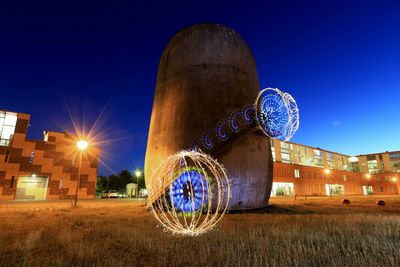 Low angle view of illuminated built structure against blue sky