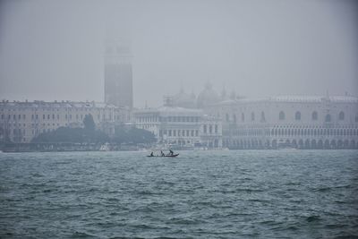 View of buildings by sea against sky