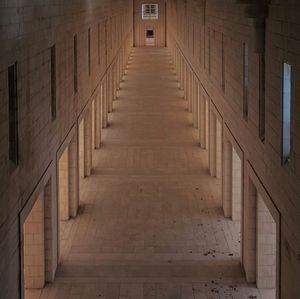 Empty narrow corridor along building