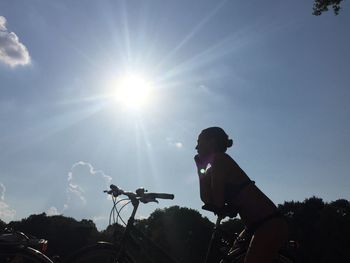 Low angle view of sun shining through clouds