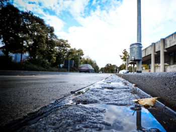 Close-up of road against sky in city