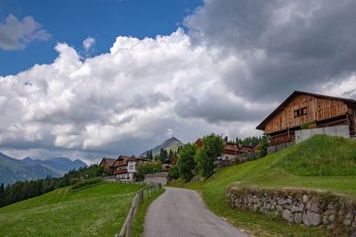 Houses by road amidst buildings against sky