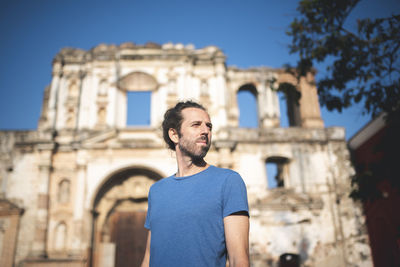 Mid adult man standing in temple against sky