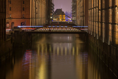 Reflection of illuminated bridge in water at night