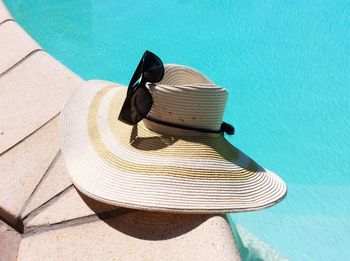 High angle view of hat and sunglass at poolside