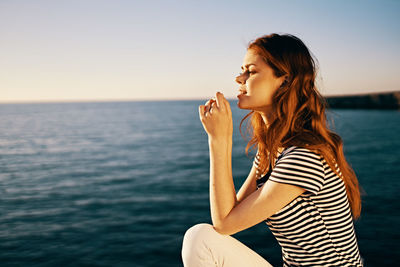 Beautiful woman against sea against sky