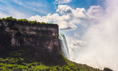 Scenic view of waterfall against sky