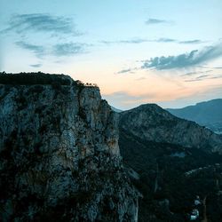 Scenic view of rocky mountains against sky at sunset