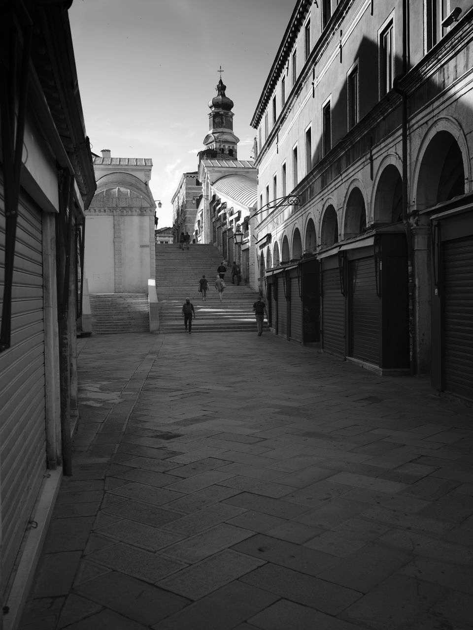 PEOPLE WALKING ON STREET BY BUILDINGS IN CITY