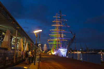 Illuminated harbor against sky at night