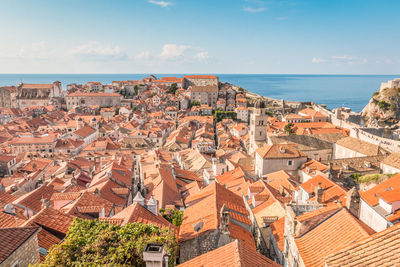 High angle view of townscape by sea against sky