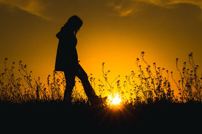 Low angle view of silhouette woman standing against sky during sunset