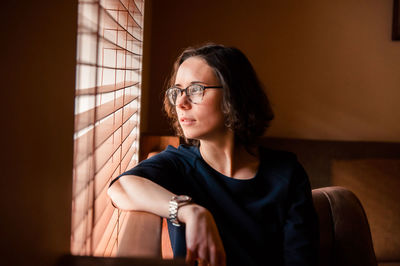 Portrait of beautiful young woman sitting at home