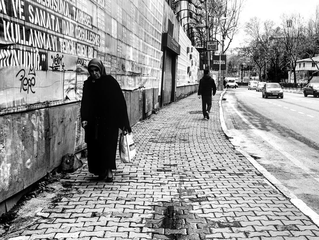 REAR VIEW OF PEOPLE WALKING ON SIDEWALK