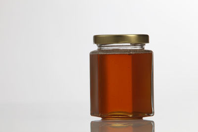 Close-up of syrup in bottle against white background
