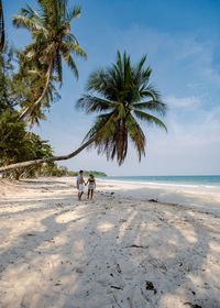 People at beach against sky