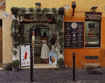 Rear view of woman standing at entrance of building