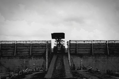 Man photographing railroad tracks against sky