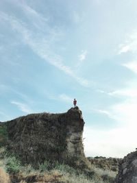 Low angle view of man on rock against sky