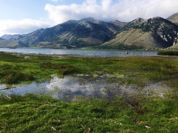 Scenic view of lake and mountains against sky