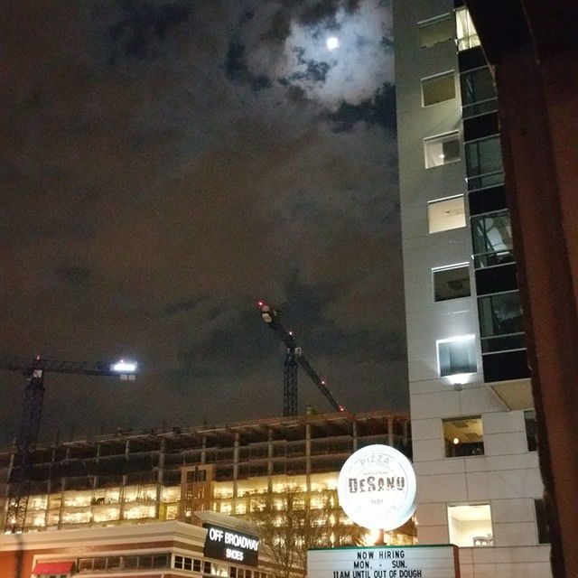 illuminated, night, architecture, built structure, building exterior, low angle view, sky, communication, text, lighting equipment, city, street light, building, western script, road sign, sign, outdoors, no people, moon, dusk