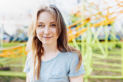 Portrait of smiling young woman standing against trees