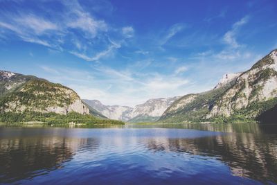 Scenic view of lake and mountains against blue sky