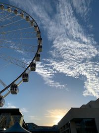 Low angle view of ferris wheel in city against sky
