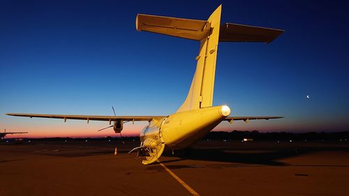 Airplane on airport runway against clear sky