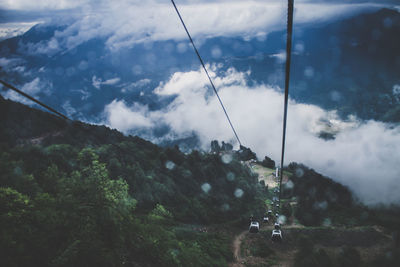 Overhead cable car over mountains against sky