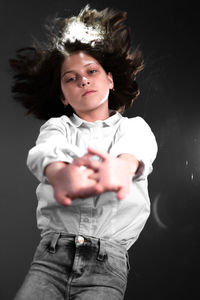 Portrait of girl standing against black background