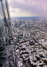 High angle view of city buildings against cloudy sky