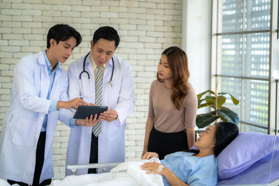 Portrait of doctor examining patient in hospital