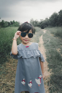 Full length of woman wearing sunglasses standing on field