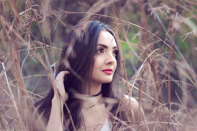 Portrait of young woman amidst grass