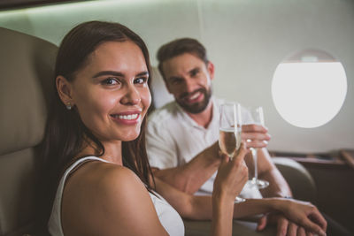 Portrait of couple drinking champagne in corporate jet