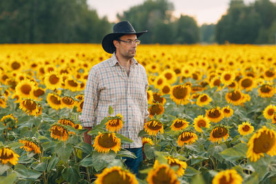 Full length of woman standing in sunflower field