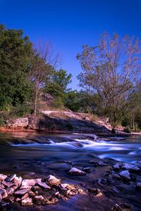 Scenic view of lake against clear blue sky