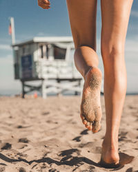 Low section of woman walking at beach