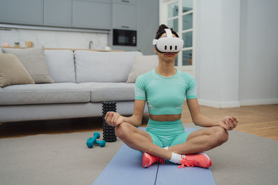 Portrait of young woman exercising at home
