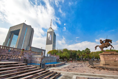 Low angle view of statue against buildings in city