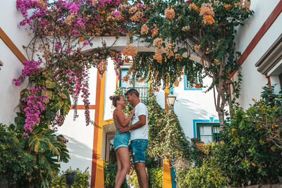 Woman standing by palm tree