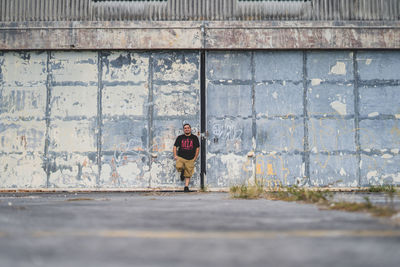 Full length of woman standing against wall