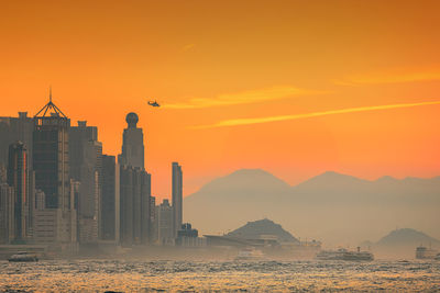 Silhouette of buildings against sky during sunset